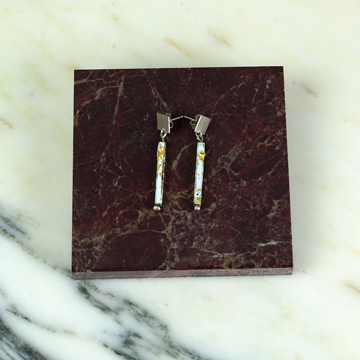 Pair of earrings on a maroon marble display stand against a marble background.  | Scarlett Cohen French | Shop Fodder