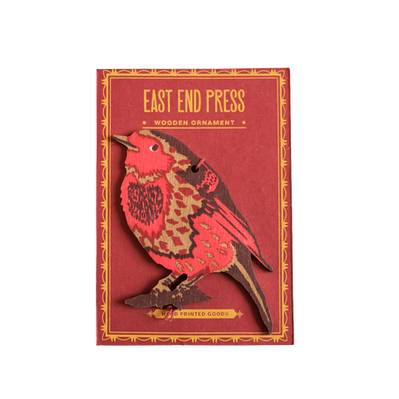 Red wooden ornament with bird design on a red background, featuring 'East End Press' branding. | Shop Fodder