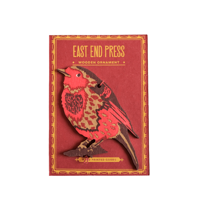 Red wooden ornament with bird design on a red background, featuring 'East End Press' branding. | Shop Fodder