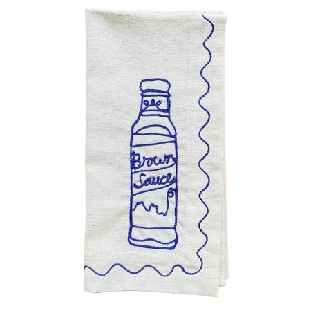 White towel with blue embroidered design of a bottle labeled 'Brown Sauce' on a white background. Embroidered Linen Napkins | See & Quin | Shop Fodder