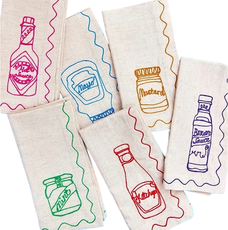 Set of fabric napkins with colorful condiment illustrations on a white background. Embroidered Linen Napkins | See & Quin | Shop Fodder