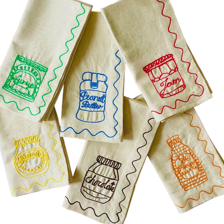 Set of fabric bags with embroidered designs on a white background. Embroidered Linen Napkins | See & Quin | Shop Fodder