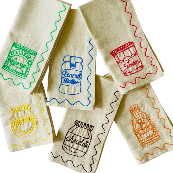 Set of fabric bags with embroidered designs on a white background. Embroidered Linen Napkins | See & Quin | Shop Fodder