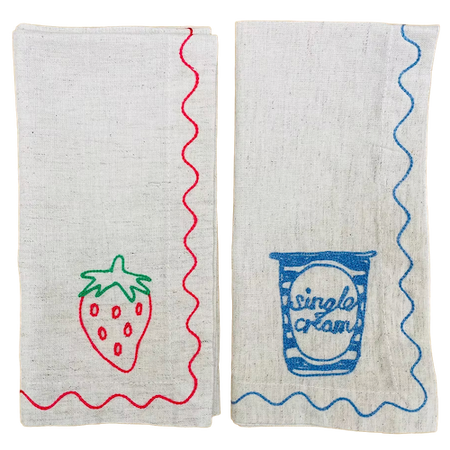 Two fabric towels with a strawberry design and 'Single Cream' text on a white background. Embroidered Linen Napkins | See & Quin | Shop Fodder