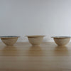 line of three handmade stoneware snack bowls taken from the side. 