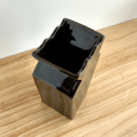 Black ceramic vase on a wooden surface. Studio ERS | Ceramic Vase | Shop Fodder