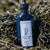 Bottle of seaweed-infused body oil on a bed of seaweed |Infused Seaweed Body Oil | WASI Seaweed | Shop Fodder