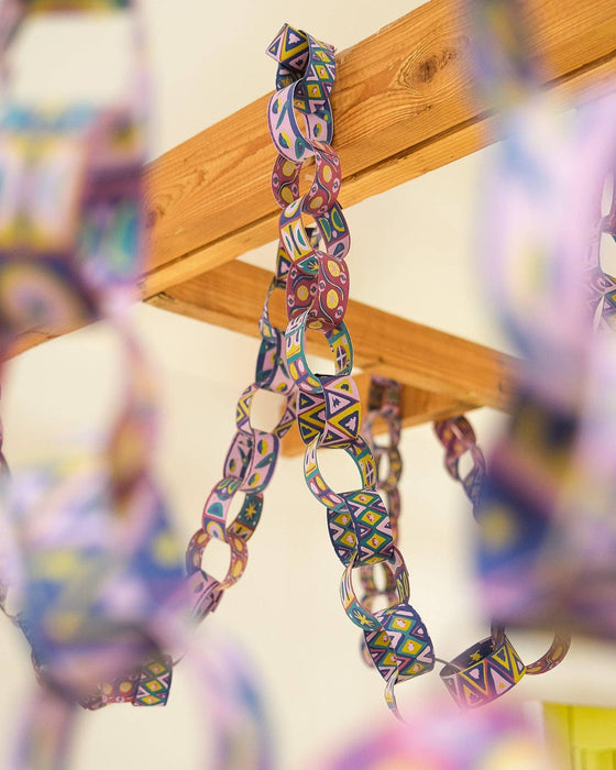 Colorful chain hanging from a wooden beam with a blurred background