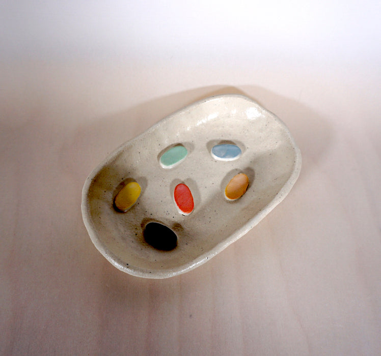a ceramic soap dish with colourful dots on the bottom by Beci Callow