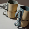 4 mugs stacked in 2's on a grey table. 