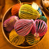 Colorful decorative balls on a wooden surface with pumpkins and nuts in the background | East End Press | Shop Fodder
