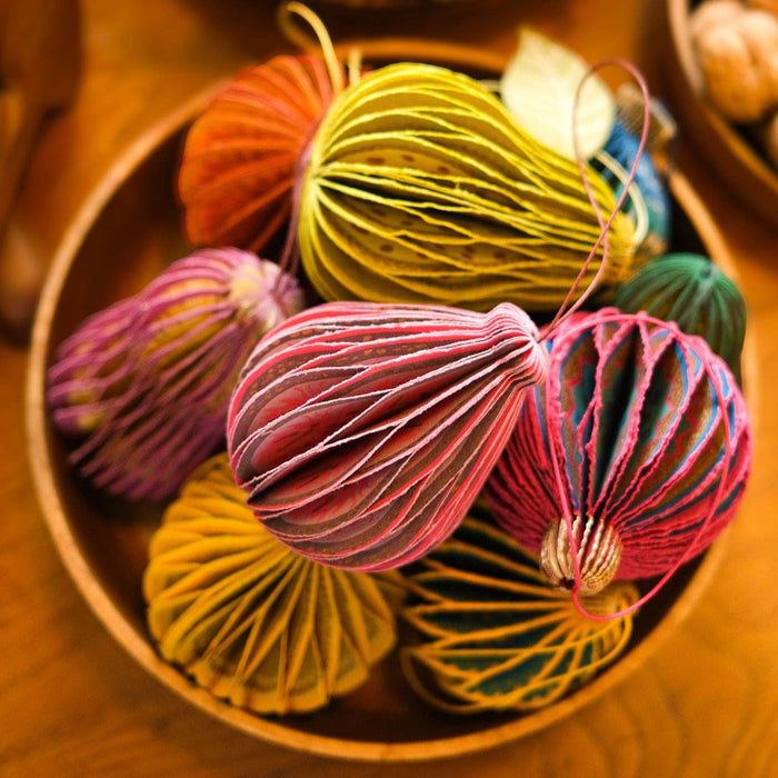 Colorful decorative balls on a wooden surface with pumpkins and nuts in the background | East End Press | Shop Fodder