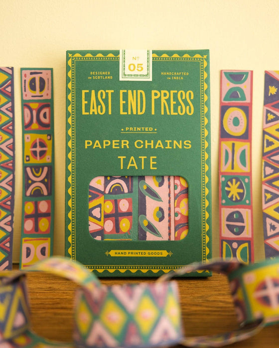 Packaging of East End Press paper chains with colorful geometric patterns on a wooden surface.